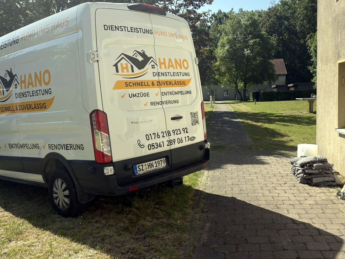 Weißer HANO-Transporter vor einem Wohnhaus, daneben Möbeldecken und Rollbretter