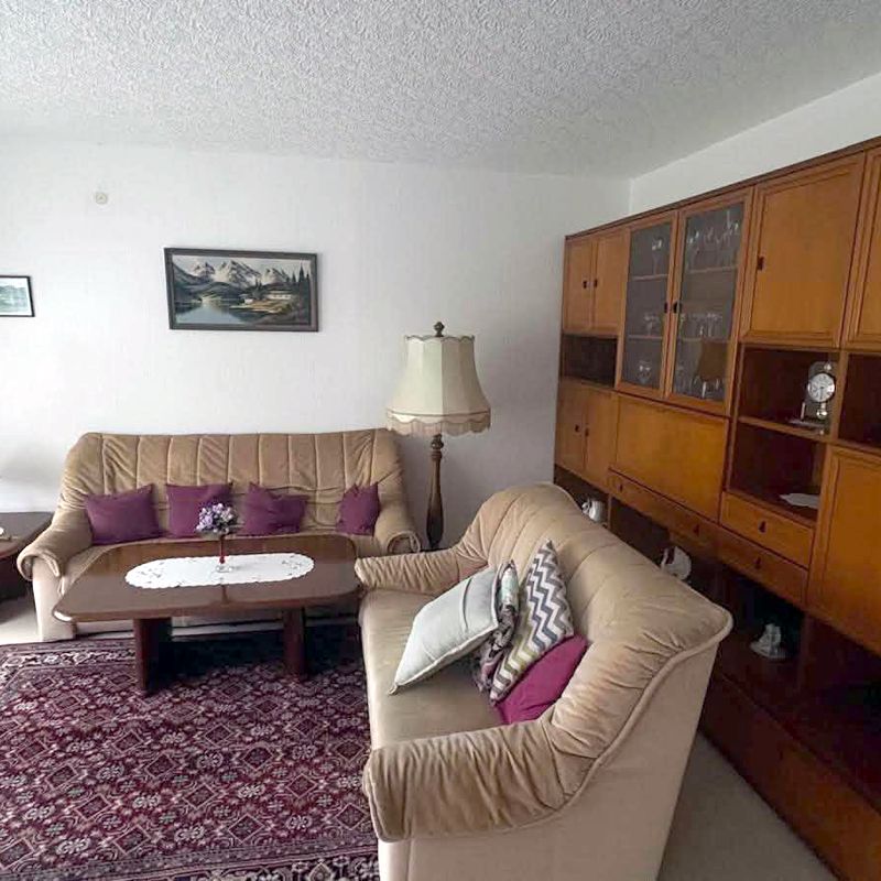 Möbliertes Wohnzimmer mit Schrankwand und Sofa vor der Räumung