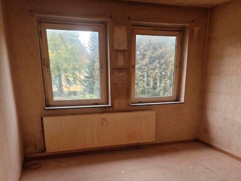 Leeres Zimmer mit zwei Fenstern nach der Räumung