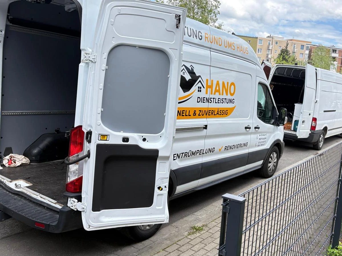Weißer HANO-Transporter mit geöffneten Hecktüren am Straßenrand, dahinter ein zweiter Transporter